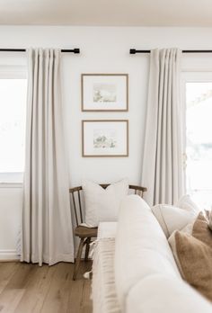 a living room with white walls and curtains