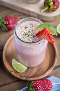 a strawberry margarita in a mason jar with limes and strawberries on the side