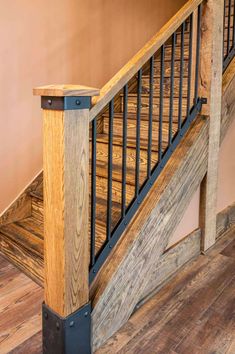 a wooden stair case with metal handrails