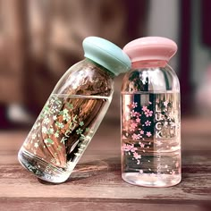 two glass jars with flowers painted on them