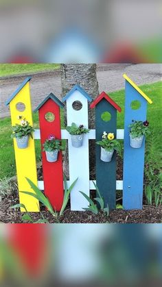 a group of colorful birdhouses sitting on top of a grass covered field