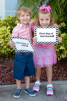 two young children holding signs that say first day of school