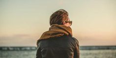 a person standing on the beach looking out at the water