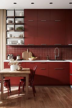 a kitchen with red cabinets and wooden flooring is pictured in this image, there are two chairs at the table