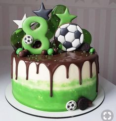 a soccer themed cake with chocolate icing and decorations on the top is decorated in green, white and black