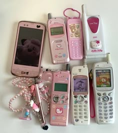 there are many different types of cell phones on the table with one being a teddy bear