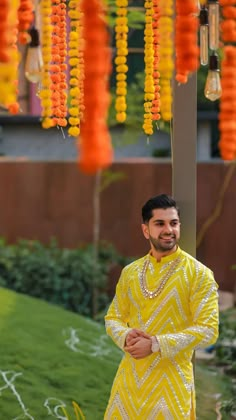 a man dressed in yellow standing under an orange and yellow decoration