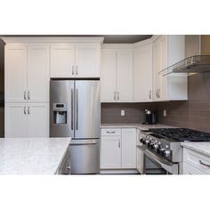 a kitchen with white cabinets and stainless steel appliances, including a silver refrigerator freezer