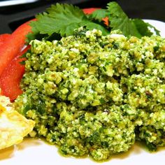 a white plate topped with broccoli covered in sauce next to sliced up carrots