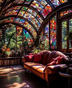 a living room filled with lots of windows covered in colorful stained glass panels and furniture