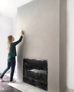 a woman is painting the wall in her living room, and she's using an instagram