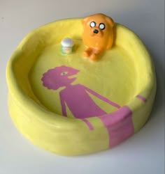 a yellow and pink bowl with a cartoon figure in it