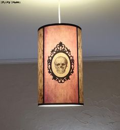 a lamp shade with a skull on it hanging from a ceiling fixture in a room