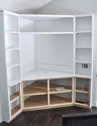 a white bookcase with shelves and drawers on it