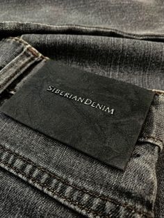 a label on the back pocket of a pair of dark blue jeans with white stitching