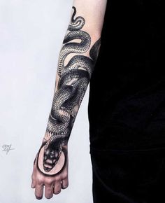 a man's arm with a snake tattoo on it