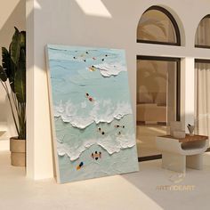 a painting is displayed in front of a large window with an ocean scene on it