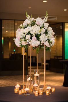 the centerpiece is surrounded by candles and flowers