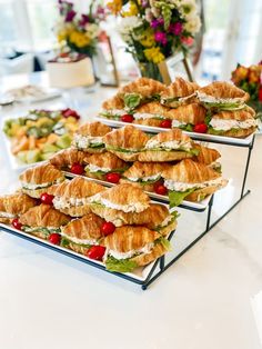 there are many sandwiches on the trays ready to be served at this wedding reception