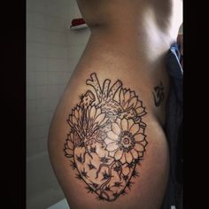 a woman's stomach with tattoos on it and flowers in the shape of a heart