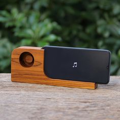 a wooden device with a black and brown speaker on it's side sitting on top of a piece of wood