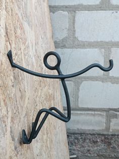 a metal figure on the side of a brick wall next to a stone wall and cement block