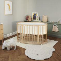 a baby's room with a wooden crib and rugs on the floor