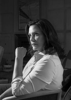 a black and white photo of a woman sitting in a chair with her arms crossed