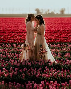 two brides standing in a field of tulips