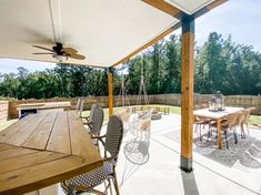 an outdoor dining area with table, chairs and ceiling fan in the middle of it