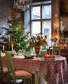 a dining room table set for christmas with candles and ornaments on the table next to it