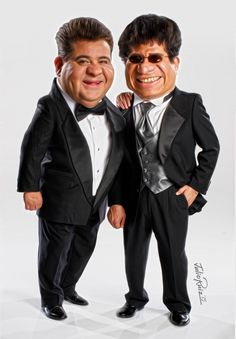 two men dressed in black tuxedos pose for the camera with their arms around each other