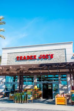 trader joe's store front with palm trees in the foreground and blue sky above