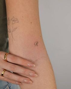 a woman's arm with a flower tattoo on the left side of her arm