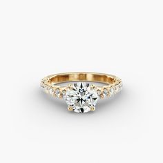 a yellow gold engagement ring with an oval cut diamond in the center and side stones