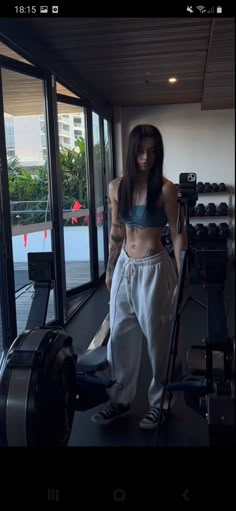 a woman standing in front of a gym machine