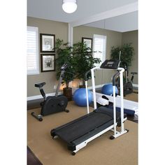 there is an exercise room with treadmills and exercise balls on the carpeted floor