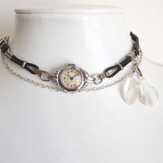 Another unique handmade-by-me necklace.  A vintage dainty 1950s ladies silvertone Swiss-made Ingersoll wristwatch with a black leather and metal banded strap has been given an alternative life as this one-of-a-kind choker-style piece of jewellery.  No one else will be wearing one exactly like it and for all its scuffs and marks, it still has a lot of character!  A 'Netonia rhodium-plated N.S' bracelet from another antique wristwatch and a few paperclip chain links have been added to give a total Watch Choker, Cocktail Watch, Handmade Watch, Chain Links, Choker Style, Choker Necklaces, Watch Necklace, Metal Bands, Leather Band