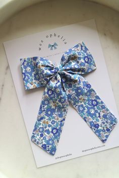 a blue and white flowered bow on top of a card