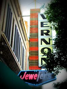 an old neon sign on the side of a building