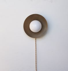 a white ball hanging from the side of a wall with a rope attached to it