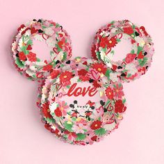 a mickey mouse head with the word love on it's face, surrounded by flowers and hearts