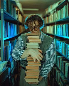 a man is holding a stack of books in front of his face