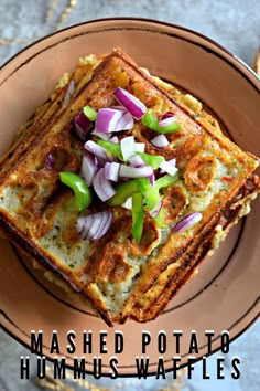 two pieces of toast with onions and green peppers on top, sitting on a plate