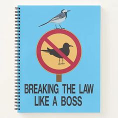 a notebook with a bird sitting on top of it, reading breaking the law like a boss