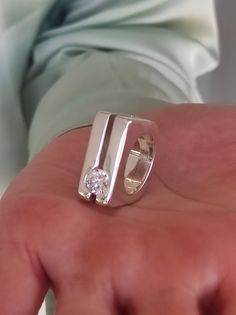 a person holding a ring with a diamond in it