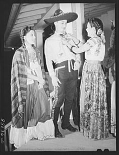 an old black and white photo of two people dressed in mexican gaucho attire