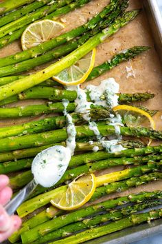 asparagus with lemons and mayonnaise in a baking pan on a table