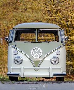 an old vw bus parked in front of some trees