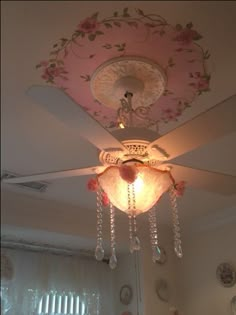 a pink ceiling fan with crystal chandelier hanging from it's center piece